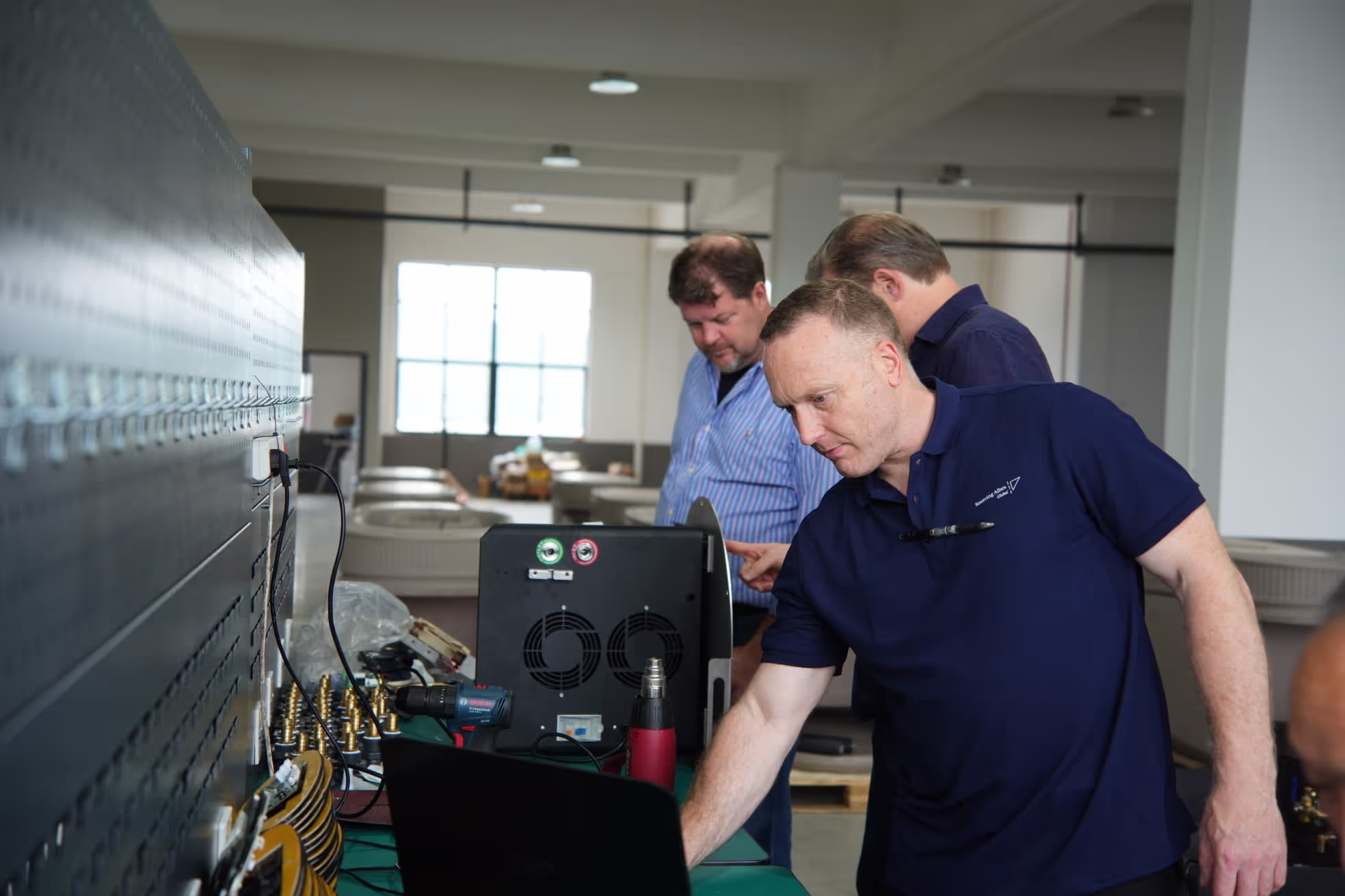 Sourcing Allies engineers testing a production unit on the factory floor
